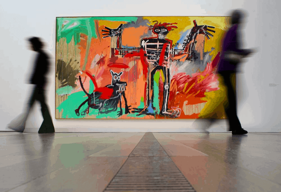 Visitors pass in front of a painting by Jean-Michel Basquiat titled "Boy and Dog in a Johnnypump" in Basel. Photographer: Fabrice Coffrini/Afp Via Getty Images.